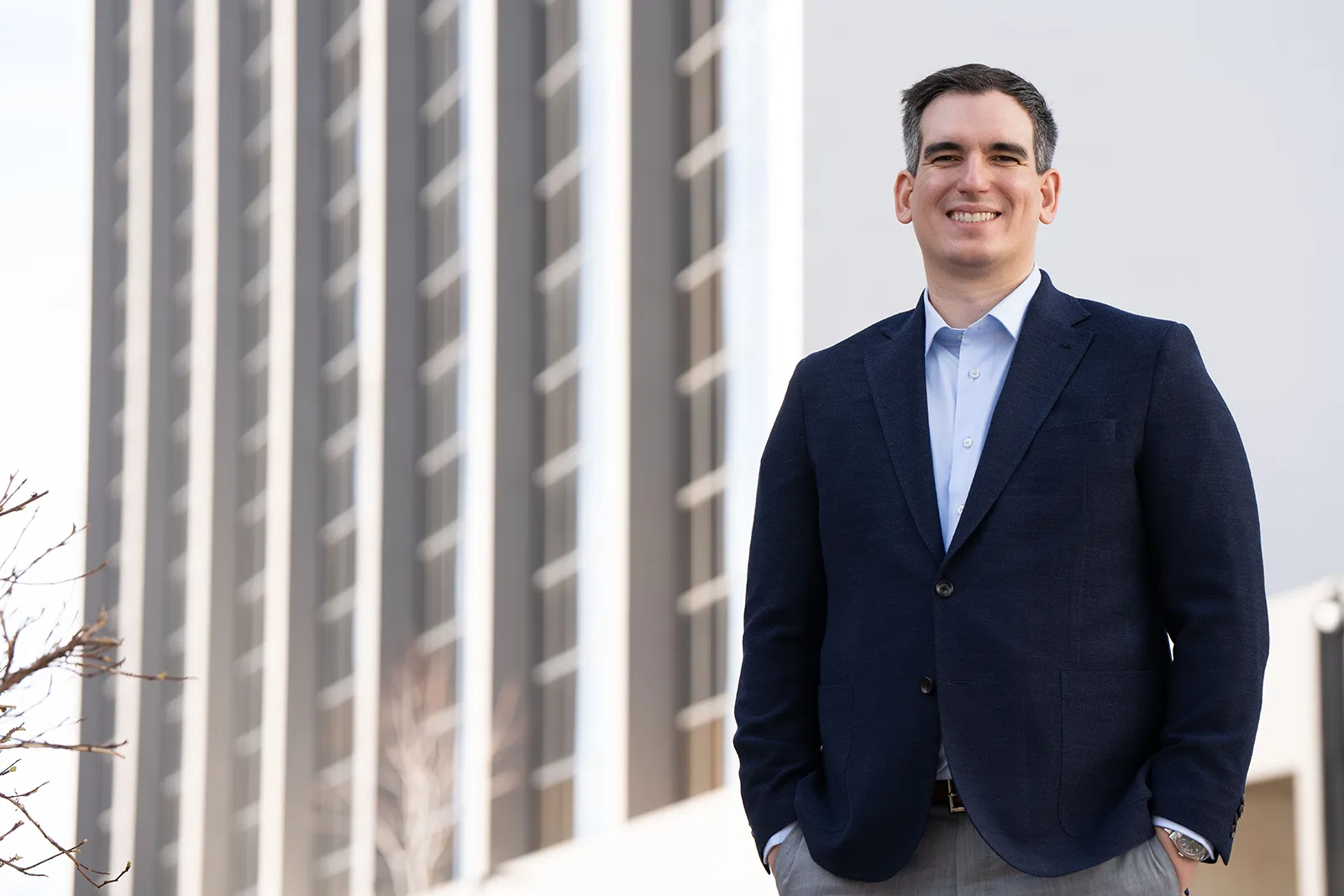 Spiro Hristopoulos in a navy blazer standing outside a Denver office building